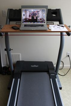 a laptop computer sitting on top of a treadmill