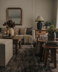 a living room filled with furniture and a large mirror on the wall above it's headboard