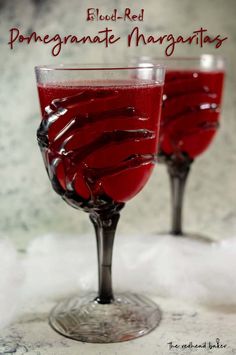 two glasses filled with red liquid sitting on top of snow covered countertop next to the words, elod - red pomegranate margaritas