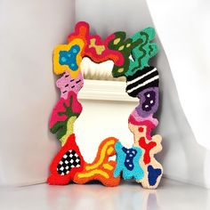 a decorative mirror is decorated with multicolored objects