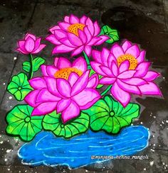 some pink flowers and green leaves are on the ground next to a blue pond with water