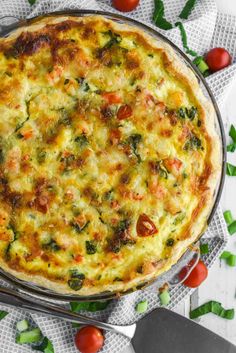 a pizza sitting on top of a metal pan covered in cheese and veggies