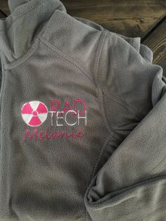 the back of a gray sweatshirt with pink and white designs on it that says pad tech mechanic