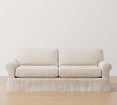 a white couch sitting on top of a hard wood floor