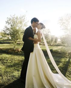 a bride and groom kissing in the sun