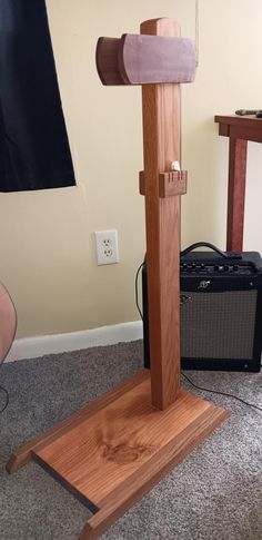 a wooden stand with an electric guitar in the background and a speaker on the floor next to it