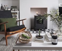 a living room filled with furniture and a fire place next to a table covered in books