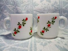 two white cups with red roses on them