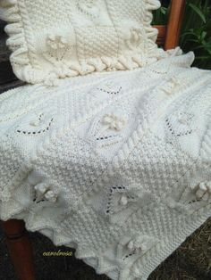 a white crocheted blanket sitting on top of a wooden chair