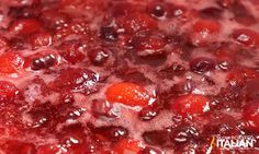 cranberry sauce with oranges and cherries cooking in a large pot on the stove