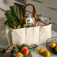 a grocery bag filled with groceries sitting on top of a table next to lemons