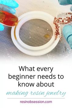 a person in blue gloves holding a plate with food on it and the words, what every beginner needs to know about making resin jewelry