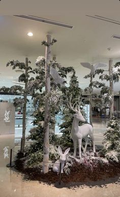 an image of a store window display with deer and trees