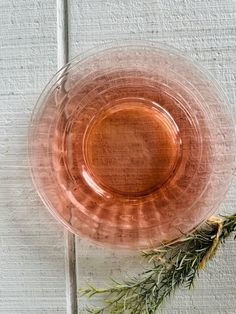 an empty glass plate with a sprig of rosemary on the rim next to it