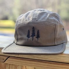 🌲🌲 5% of profits donated to preservation 🌲🌲  Gear up for your next adventure with our olive green tree 5 panel hat, the ultimate camp hat! Crafted from 100% cotton, this hat's flat bill keeps you cool and shaded as you conquer trails, lounge by the campfire, or explore the great outdoors. Your new adventure-ready essential! This hat is olive green with black embroidered trees on the front. Embroidery is custom designed by the shop owner, Alyssa, stitched on front. - 100% cotton - 5 Panel, Ca Brown Camping Hat, Adjustable Khaki Hat For Hiking, Adjustable Khaki Hiking Hats, Brown Military Hat For Outdoor, Military Style Flat Brim Trucker Hat For Outdoor, Khaki Flat Brim Trucker Hat For Outdoor, Military Style Snapback Hat With Curved Brim For Outdoor, Outdoor Khaki Snapback Hat With Flat Bill, Military Style Snapback Hat For Outdoor