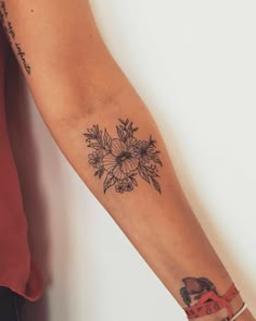 a woman's arm with a flower tattoo on the left side of her arm