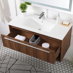 a bathroom vanity with a mirror above it and a plant in the corner next to it