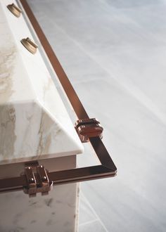 a marble counter top with brass handles on the bottom and one drawer at the end