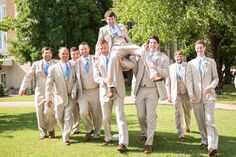 a group of men in suits and ties standing on the grass