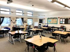 an empty classroom with desks and chalkboards on the wall, along with windows