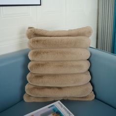 a stack of pillows sitting on top of a blue couch next to a framed photo