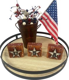 three wooden blocks with stars on them and an american flag in the background, sitting on a stand