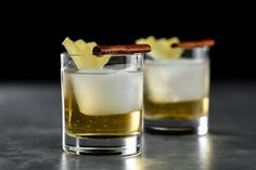 two glasses filled with alcoholic drinks on top of a table