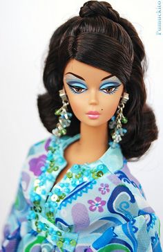 a barbie doll wearing a blue dress and earrings