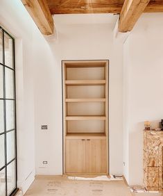 an empty room with wooden shelves and glass doors