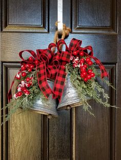 two bells decorated with red and white flowers are hanging on the front door to hang