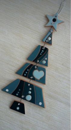 a ceramic christmas tree ornament with hearts and stars hanging from it's sides