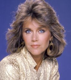 a close up of a person wearing gold clothing and large earring earrings on her head