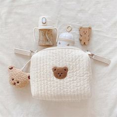 a white purse with teddy bears on it and other items in the shape of a bear