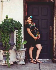 a pregnant woman standing in front of a door