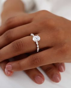 a woman's hand with a diamond ring on it