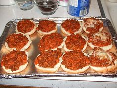 a pan filled with lots of sloppy joes on top of a counter next to bottles of water