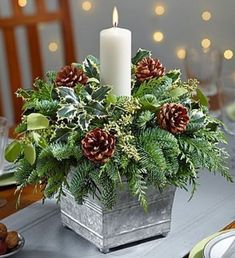 a christmas centerpiece with pine cones and greenery