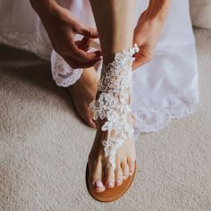 39.99 USD French lace bridal barefoot sandals offer a touch of sophistication, married with bohemian sensibilities, to give you a remarkably comfortable alternative to traditional shoes while walking thru the sand to marry the man of your dream. Featuring a French lace, shiny sequins and a really comfortable elastic ribbon, these boho wedding sandals are a popular choice for beach weddings barefoot brides. Available in a choice of two colors will complement your big day outfit splendidly. One… Boho Barefoot Sandals, Bridal Foot Jewelry, Lace Barefoot Sandals, Bride Sandals, Boho Wedding Shoes, Barefoot Sandals Wedding, Wedding Anklets, Beach Wedding Sandals, Beach Wedding Sandals Barefoot