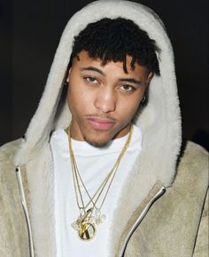 a young man wearing a hoodie and looking at the camera