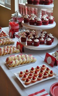 a table topped with lots of cupcakes next to plates filled with cakes and pastries