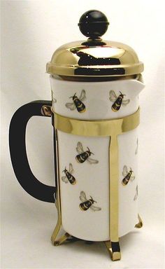 a white and gold coffee pot with bees on it