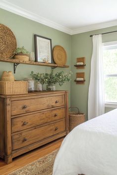 a bedroom with green walls and wooden furniture