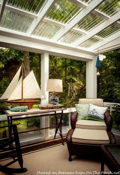 a room with a chair, table and sailboat in it