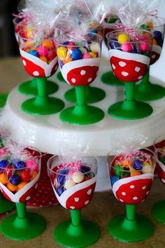 there are many candy cups on the cake stand and one is filled with candies