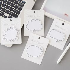 three stickers with speech bubbles on them sitting next to a laptop computer and pen