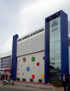 people are standing in front of a building that has colorful circles on the side of it