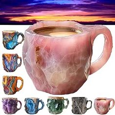 marbled coffee mugs with different colors and shapes in front of a colorful sunset