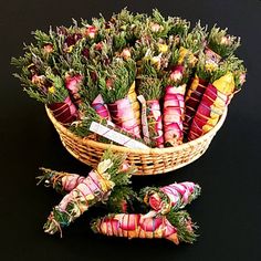 a basket filled with lots of different types of vegetables next to each other on a black surface