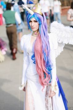 a woman dressed in white and blue with long pink hair wearing an angel wings costume