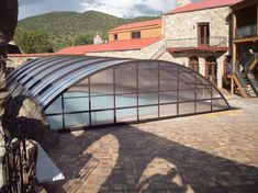 a building with a glass roof next to a stone wall